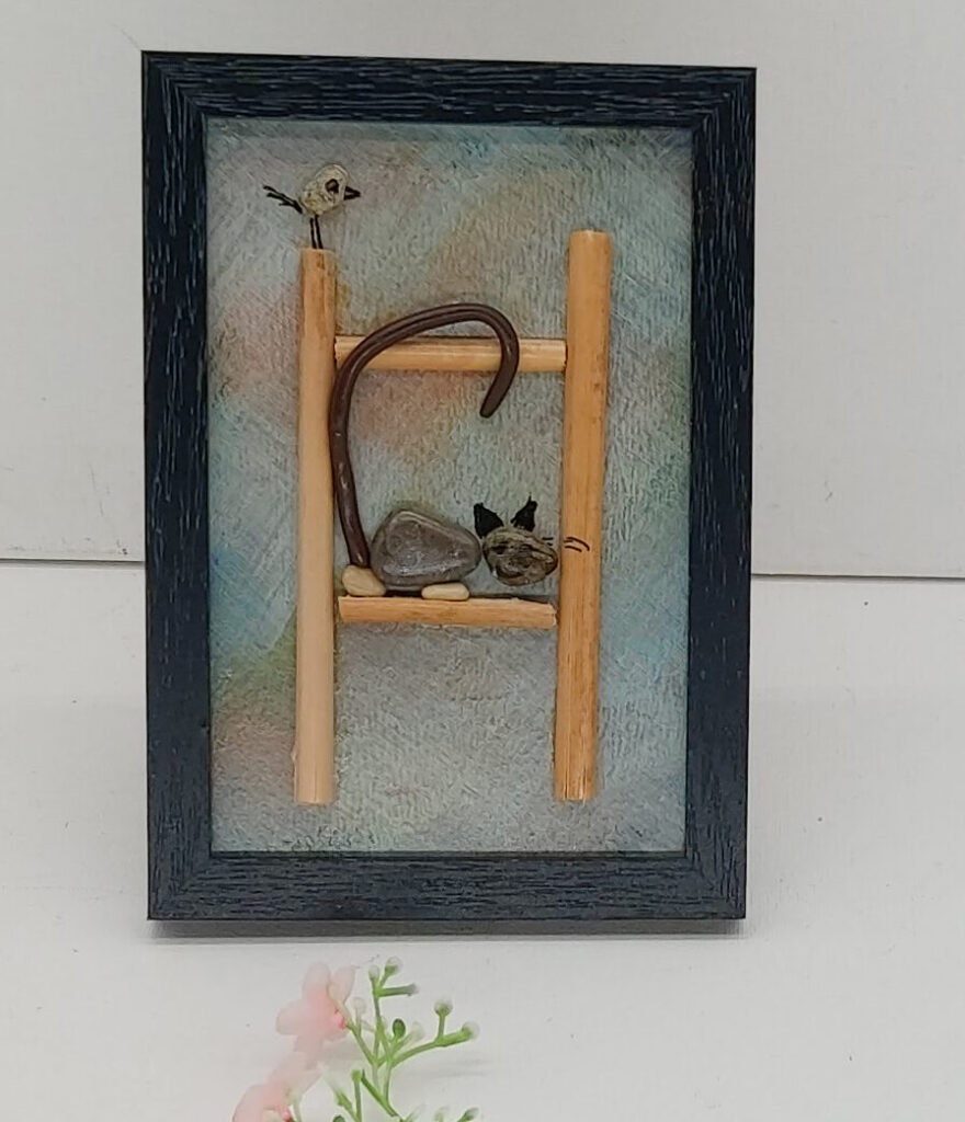 Un petit chat en galets sur une échelle